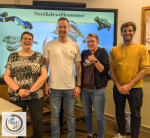 vier lachende Personen stehen vor einem Smartboard des Sachkundezentrum-Ost